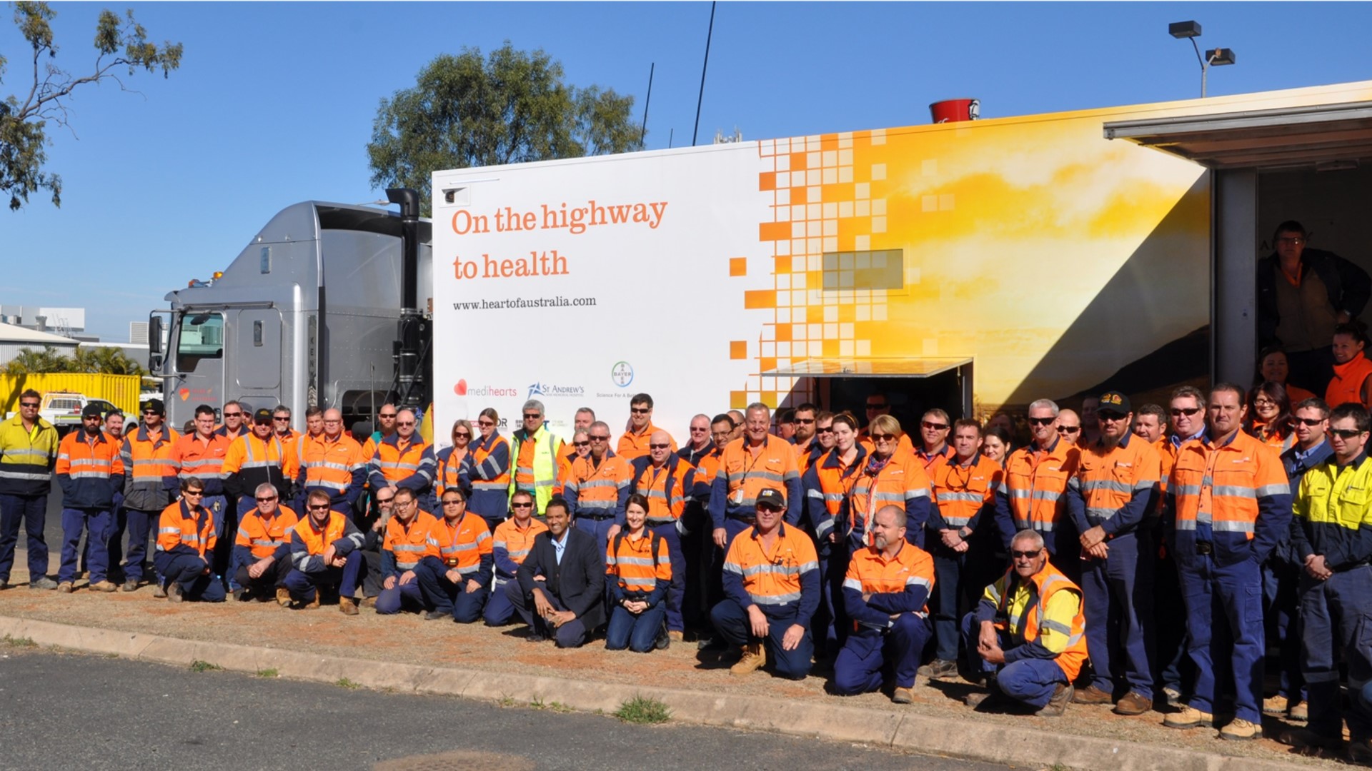 Group of Employees in high vis standing in front of HOA truck